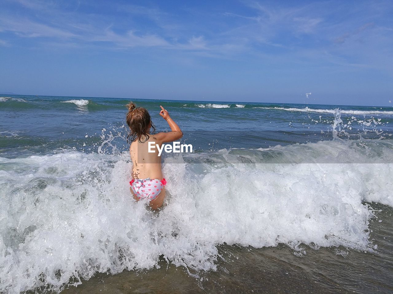 Shirtless girl in sea against sky