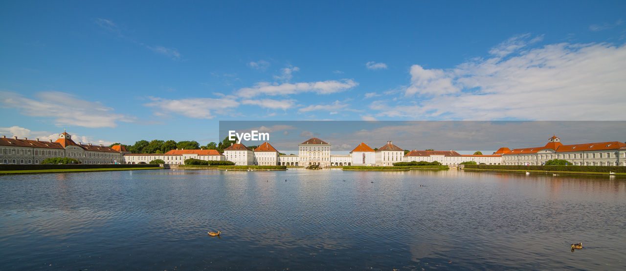 Nymphenburg palace by lake against sky in city