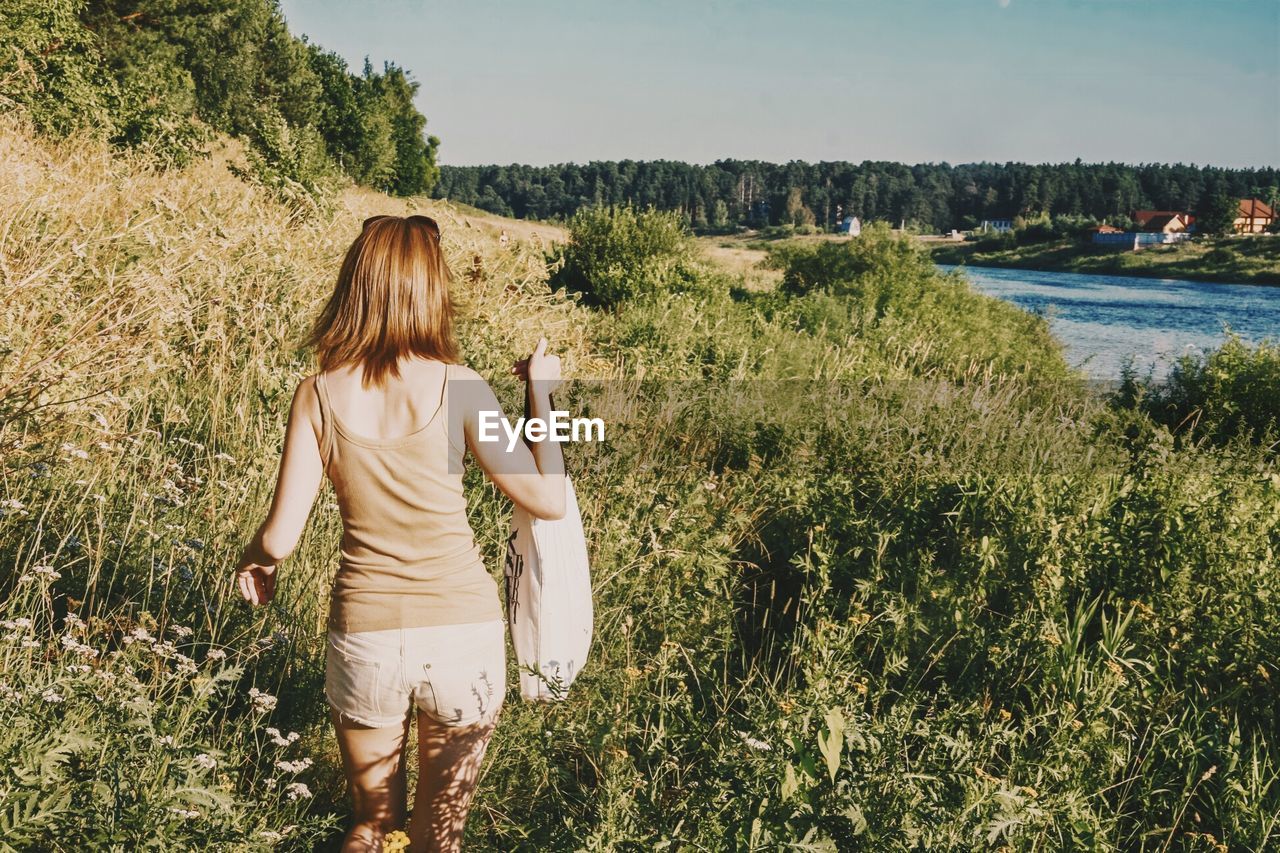 Rear view of woman walking in field