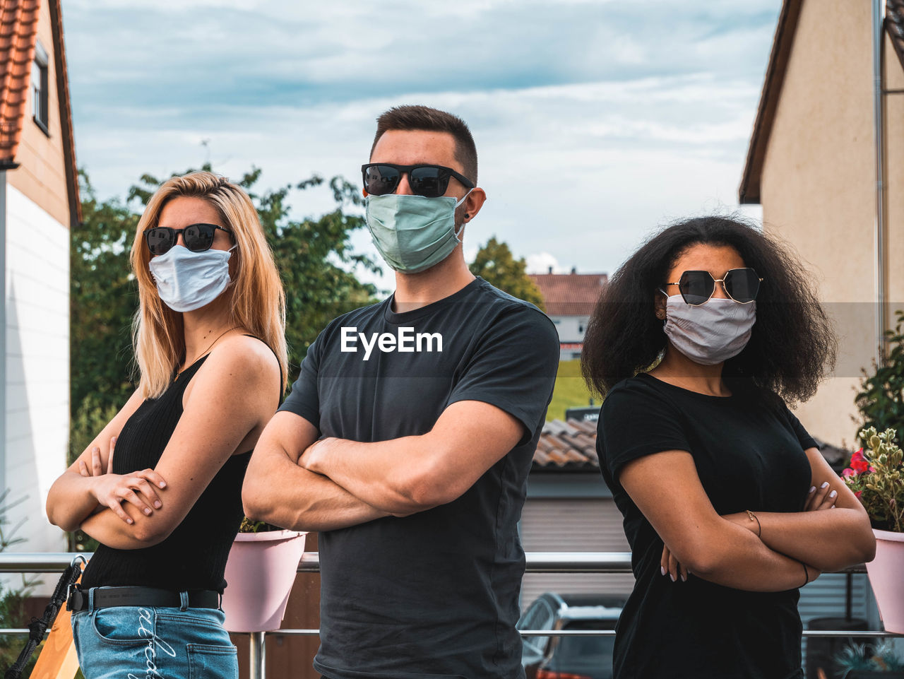 Young man and woman standing by sunglasses