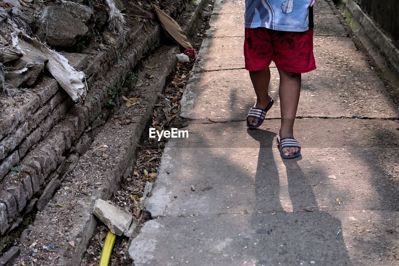 LOW SECTION OF WOMAN WALKING OUTDOORS