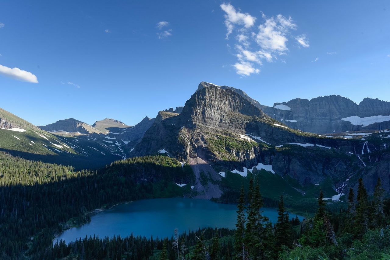 Scenic view of lake and mountains against blue sky