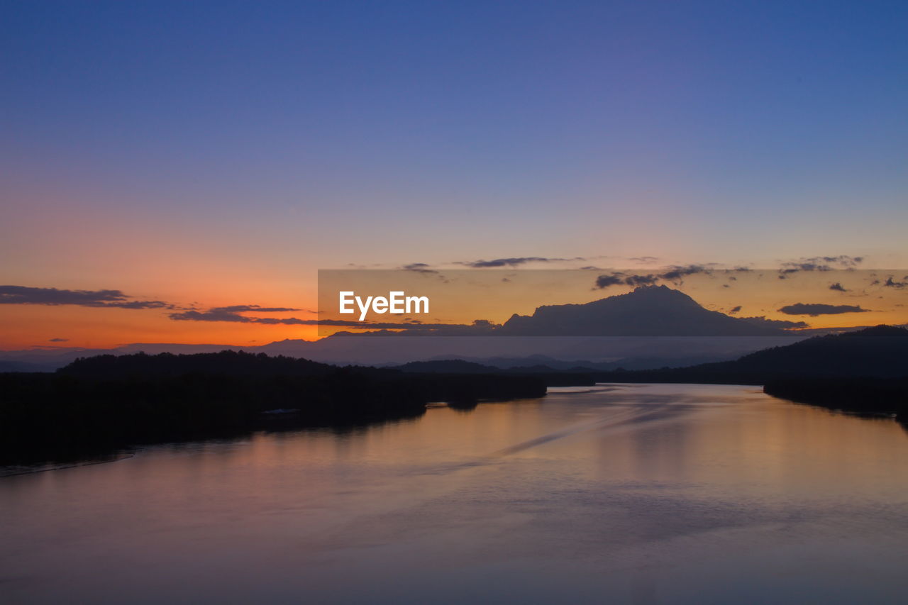 SCENIC VIEW OF LAKE AGAINST ORANGE SKY