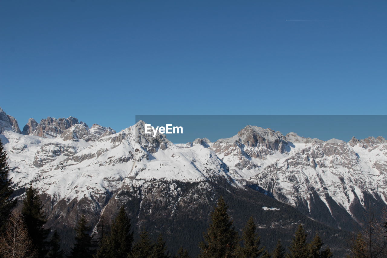 Scenic view of snowcapped mountains against clear blue sky