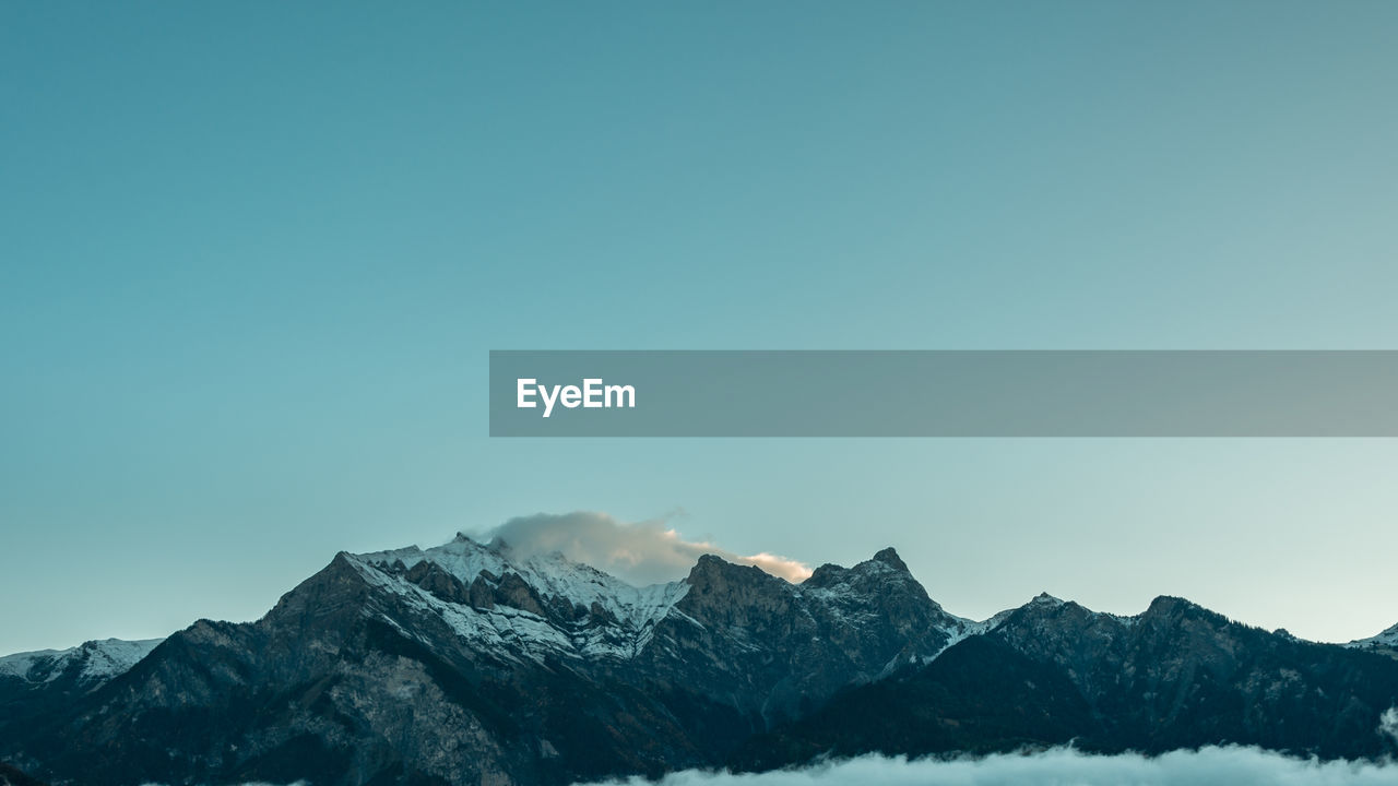 Scenic view of snowcapped mountains against clear sky