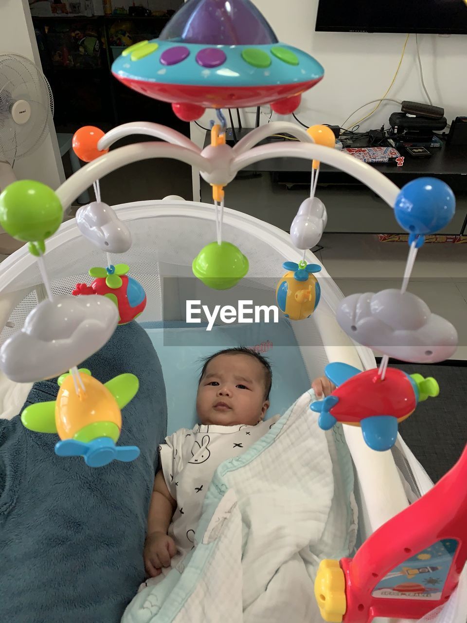 PORTRAIT OF SMILING BOY WITH BALLOONS AT HOME