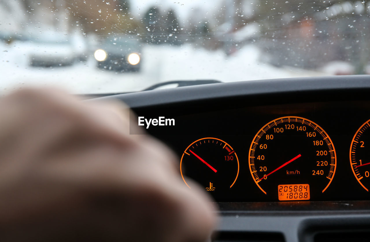 Cropped hand by car dashboard