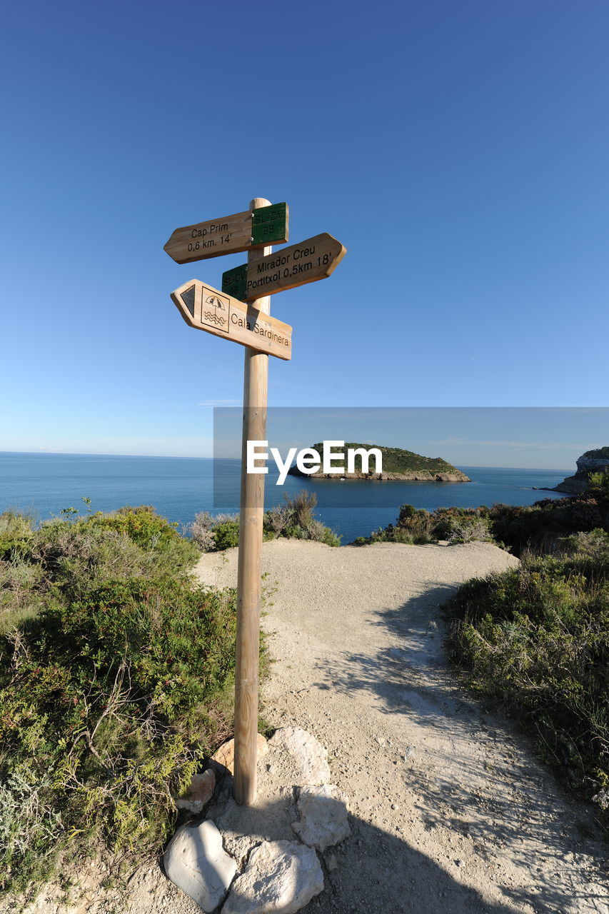 VIEW OF SIGN BY SEA AGAINST CLEAR SKY