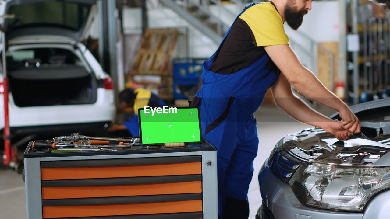 side view of man standing by car