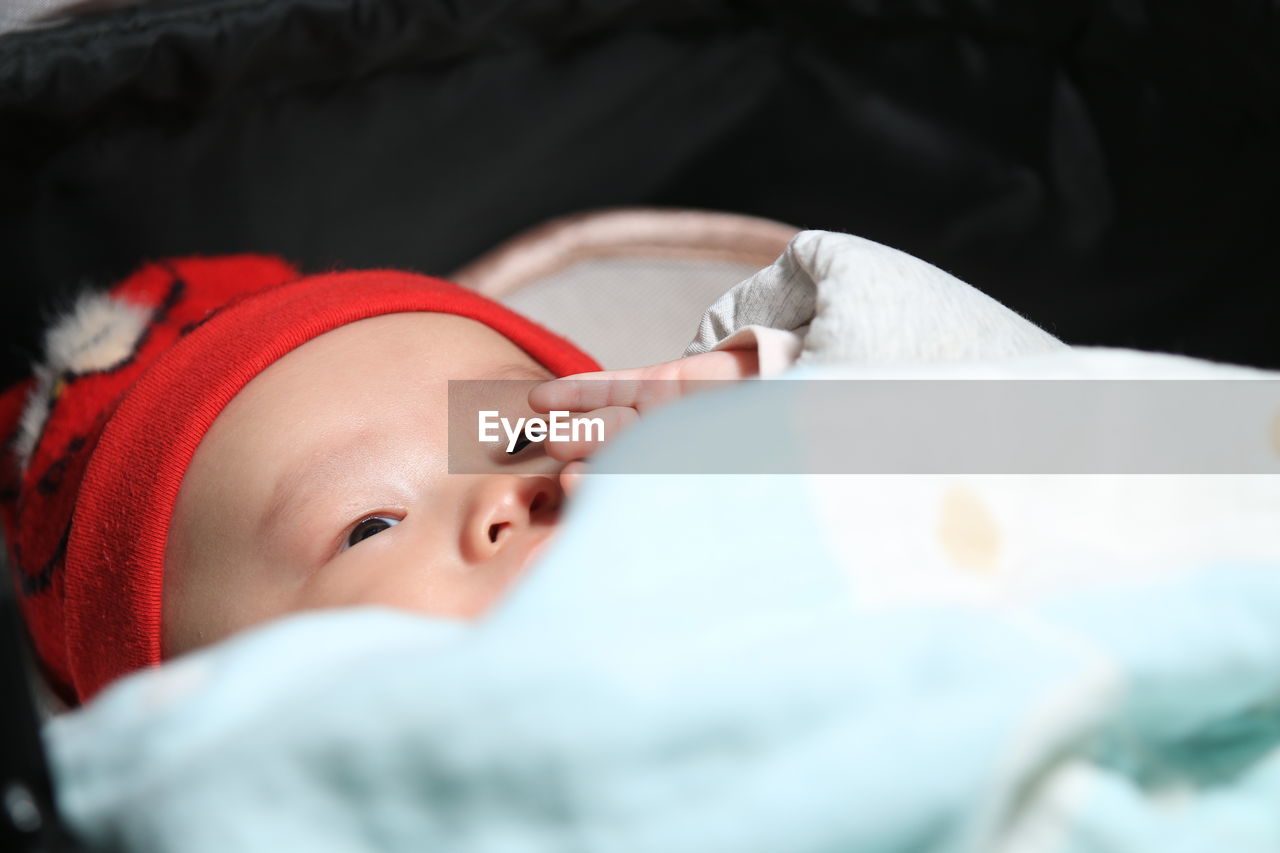 High angle view of cute baby boy lying on bed