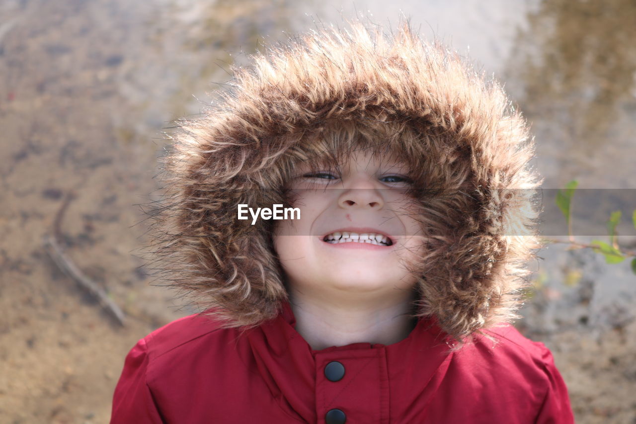 Portrait of smiling boy in fur coat