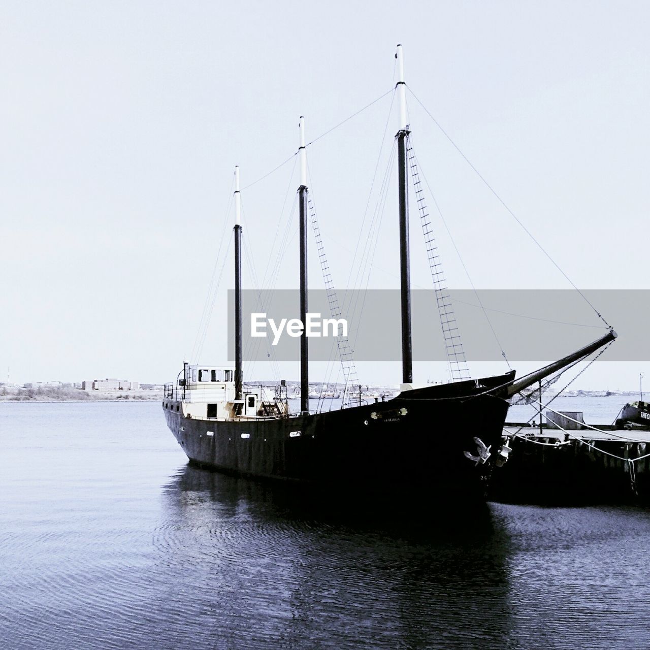 Boats in calm sea against clear sky