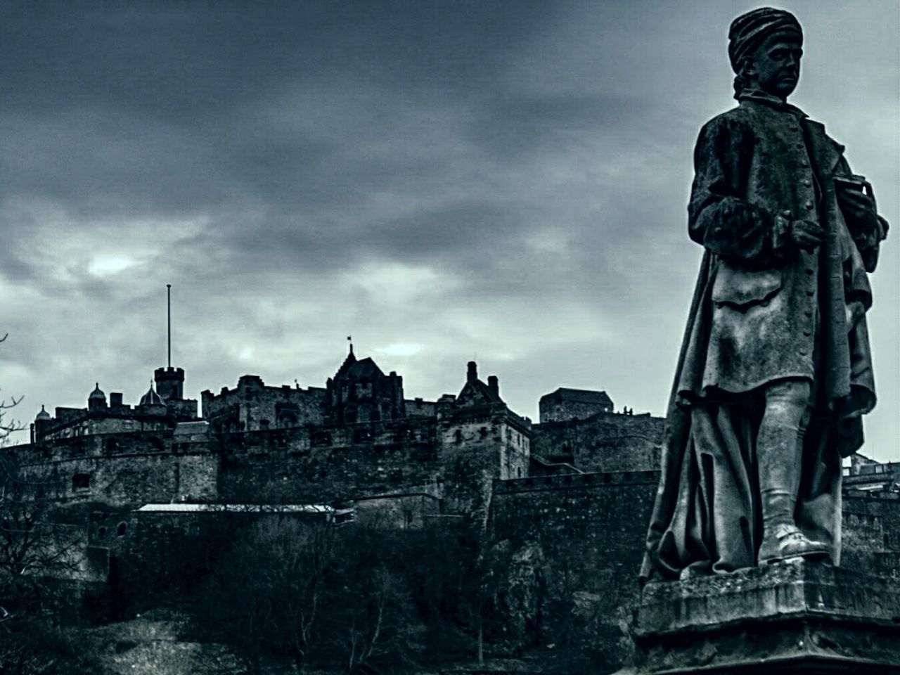 STATUE AGAINST CITYSCAPE