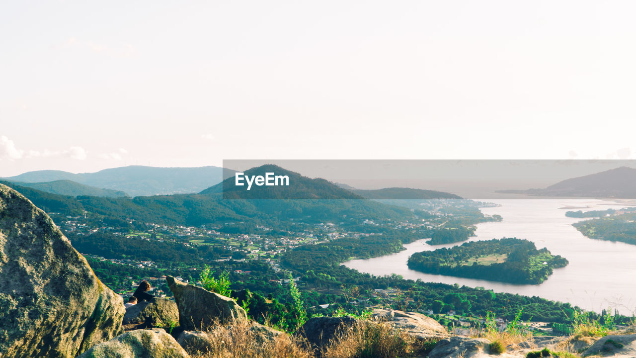 Scenic view of river and mountains against clear sky