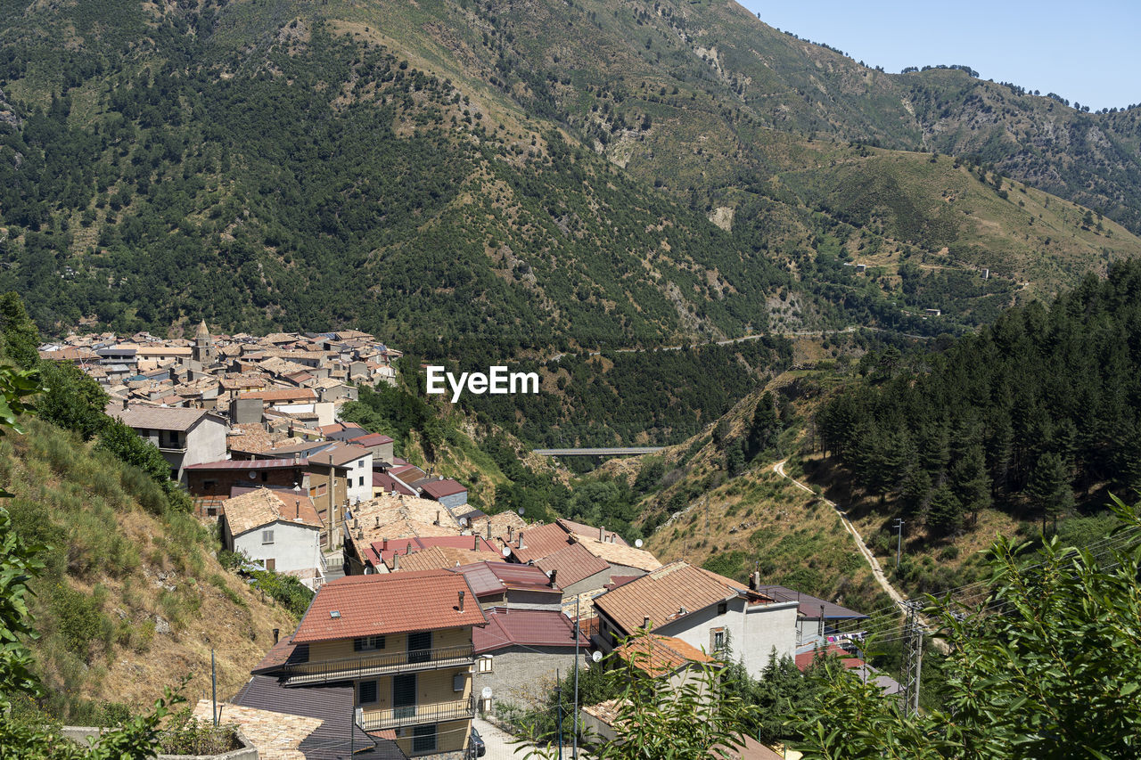HIGH ANGLE VIEW OF TOWNSCAPE BY MOUNTAIN
