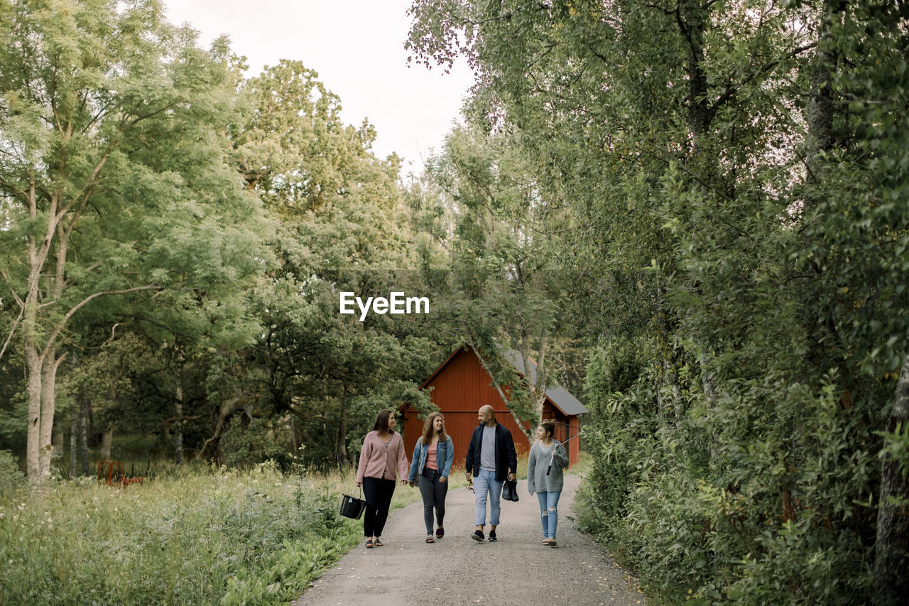 Parents with daughters walking on footpath during vacations