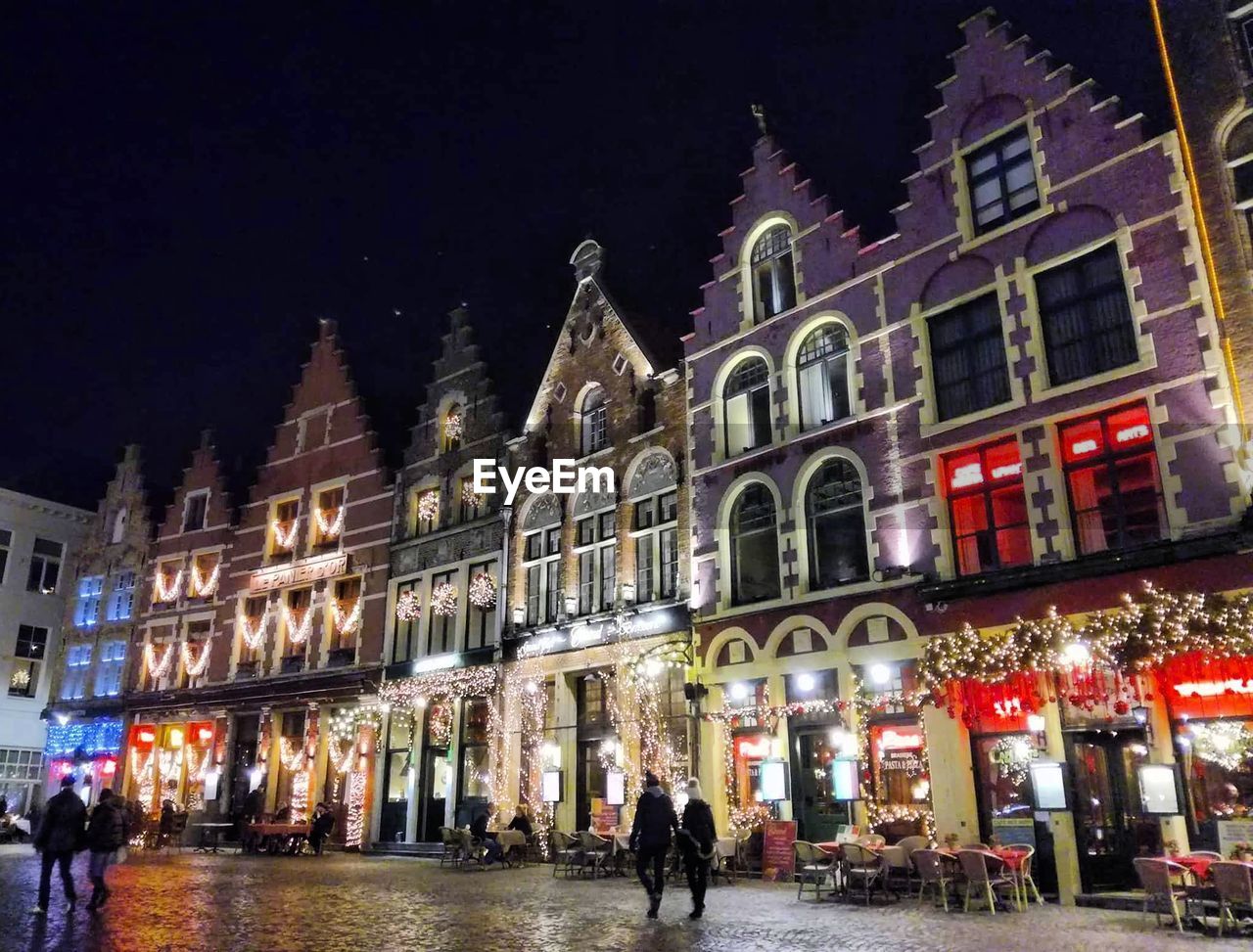 LOW ANGLE VIEW OF ILLUMINATED BUILDING IN CITY