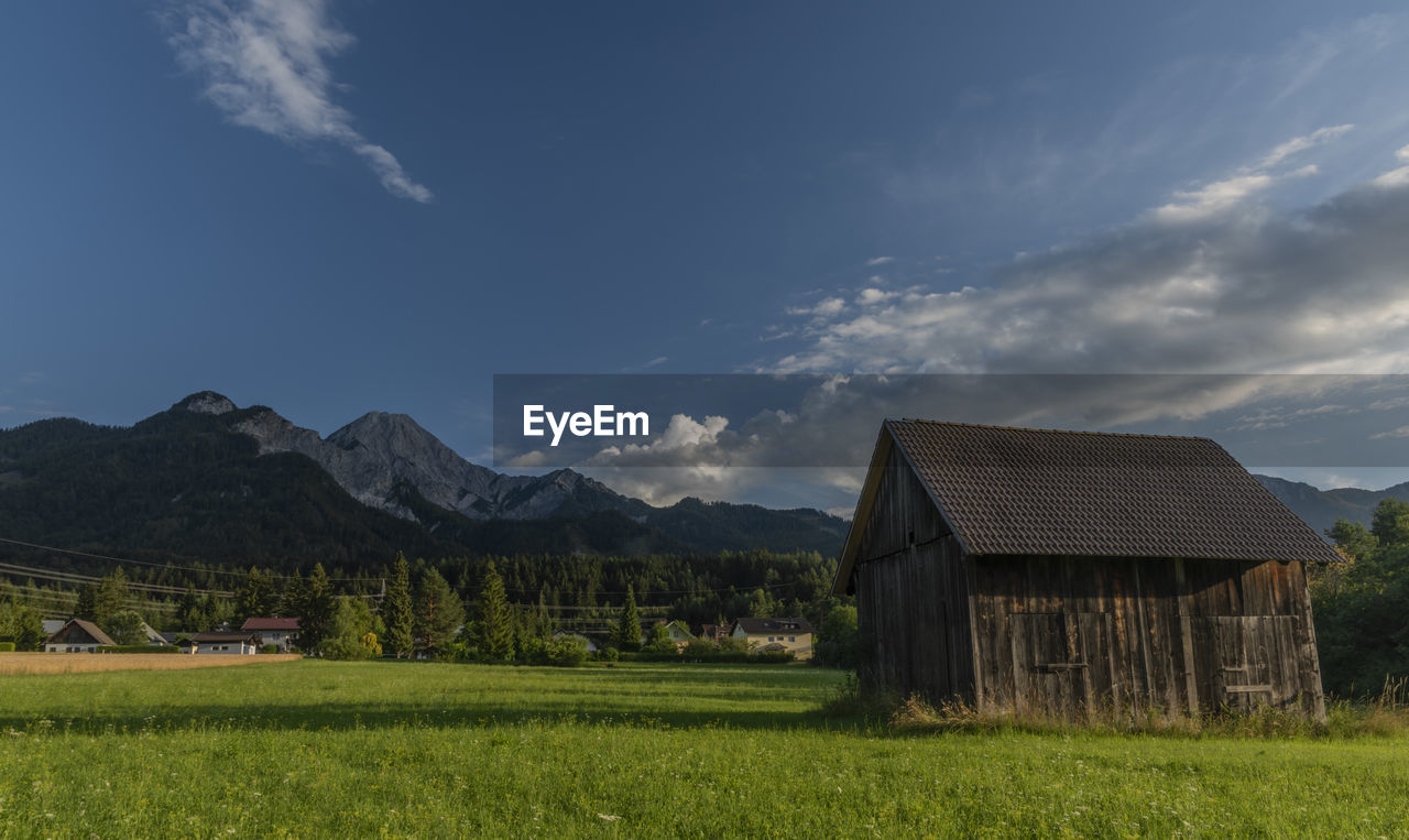 SCENIC VIEW OF FIELD AND HOUSES AGAINST SKY