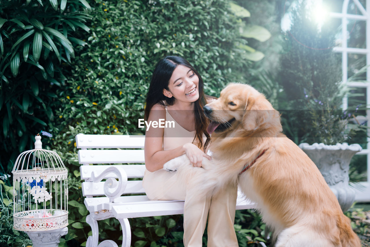 Young woman playing with dog at park