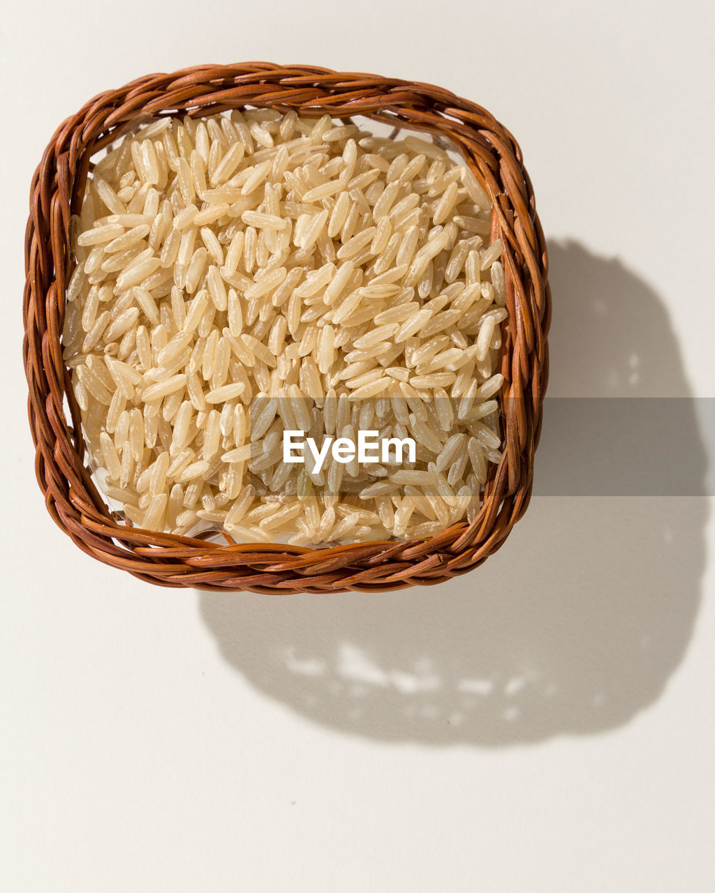 Close-up of rice in basket on white background