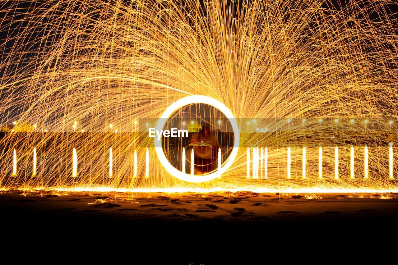 Light trails at night with steelwool with a lake view background 