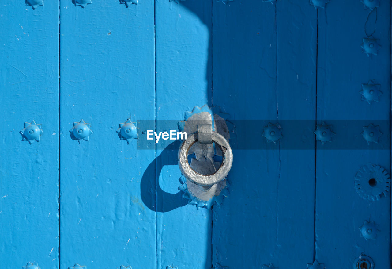 Close-up of knocker on blue door