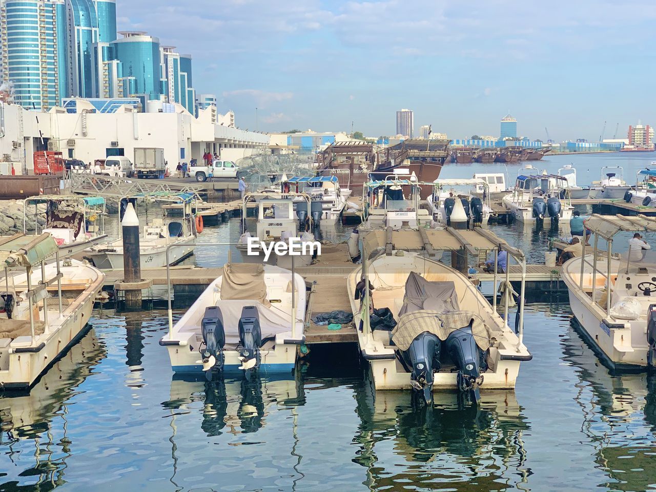 Boats moored in harbor against buildings in city