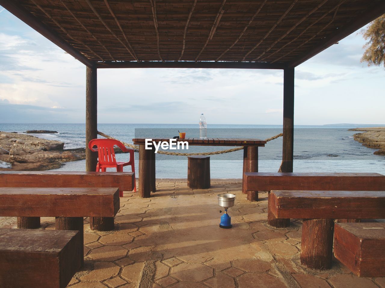 Rear view of woman sitting on pier at beach