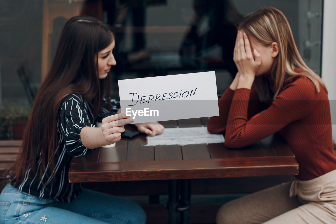 YOUNG WOMAN SITTING WITH TEXT ON THE PHONE