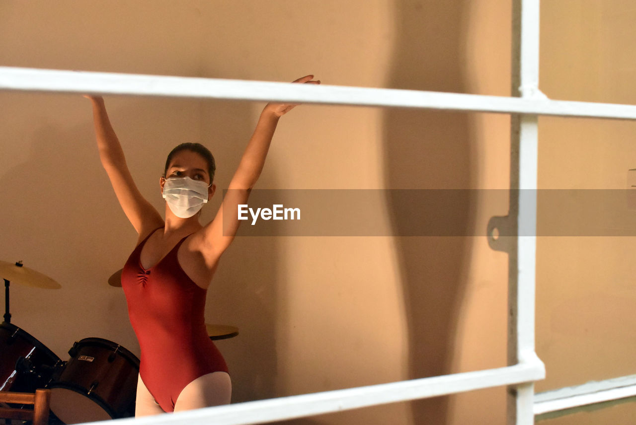 Ballet dancer with face mask, practicing at home.