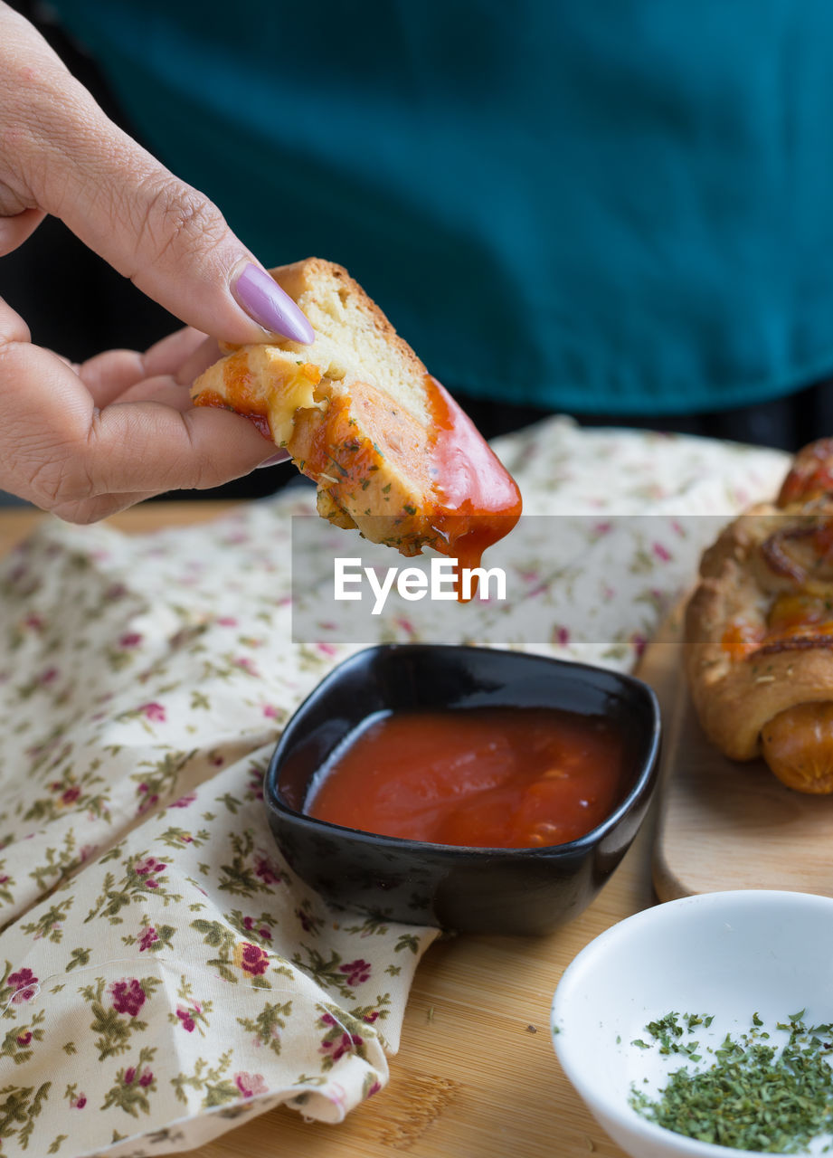 Midsection of woman having food at table