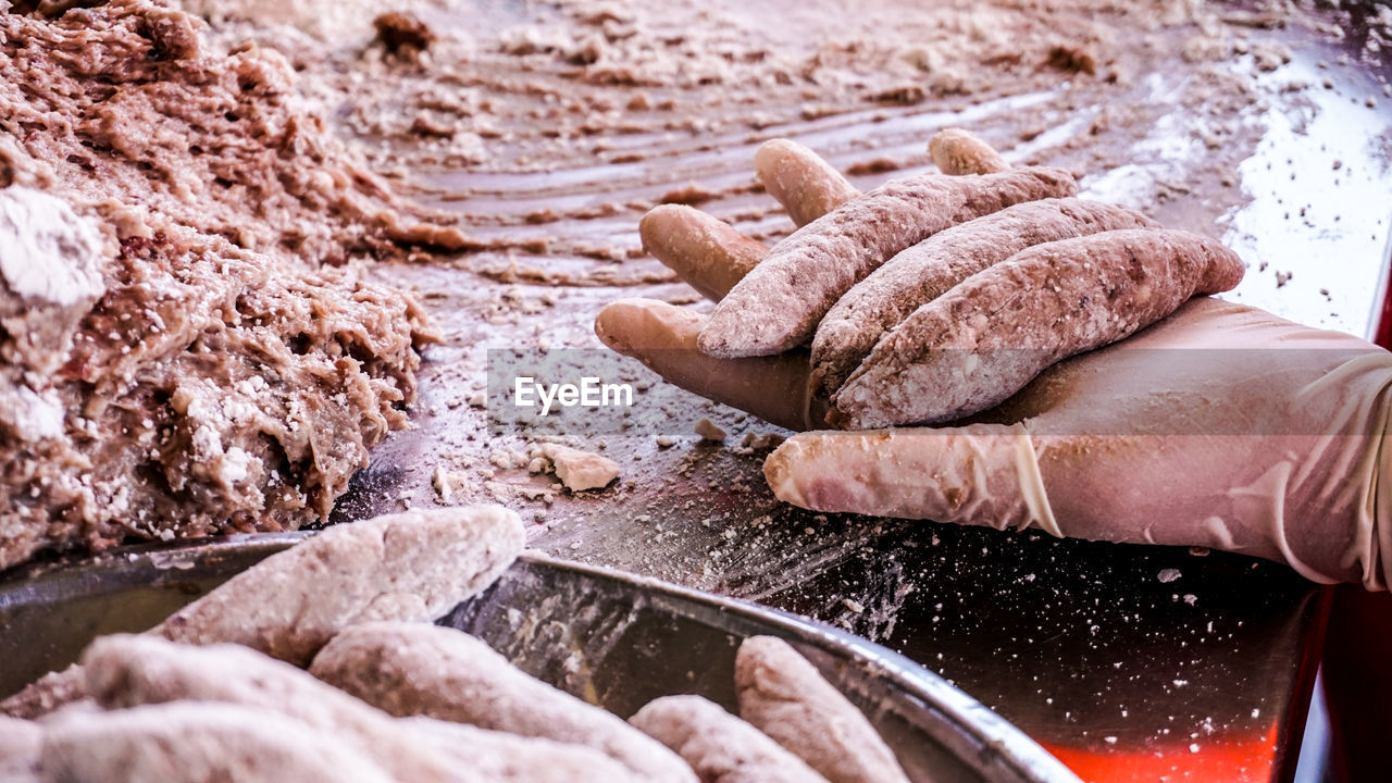 CLOSE-UP OF PERSON PREPARING MEAT