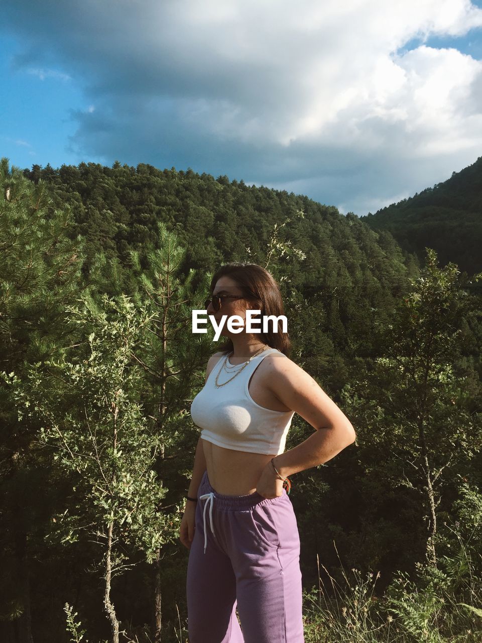 Woman standing by tree against sky