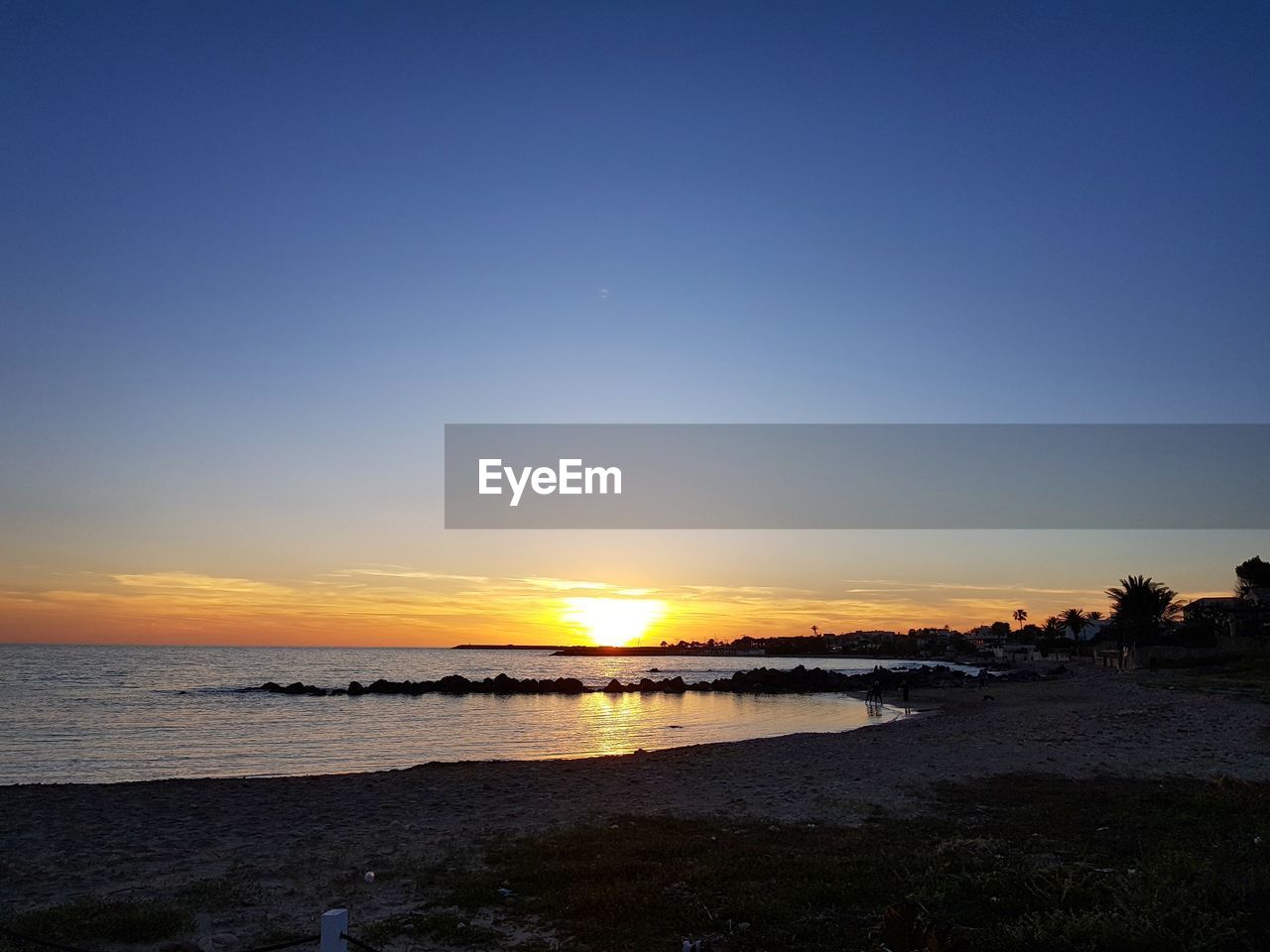 SCENIC VIEW OF BEACH AGAINST SKY DURING SUNSET