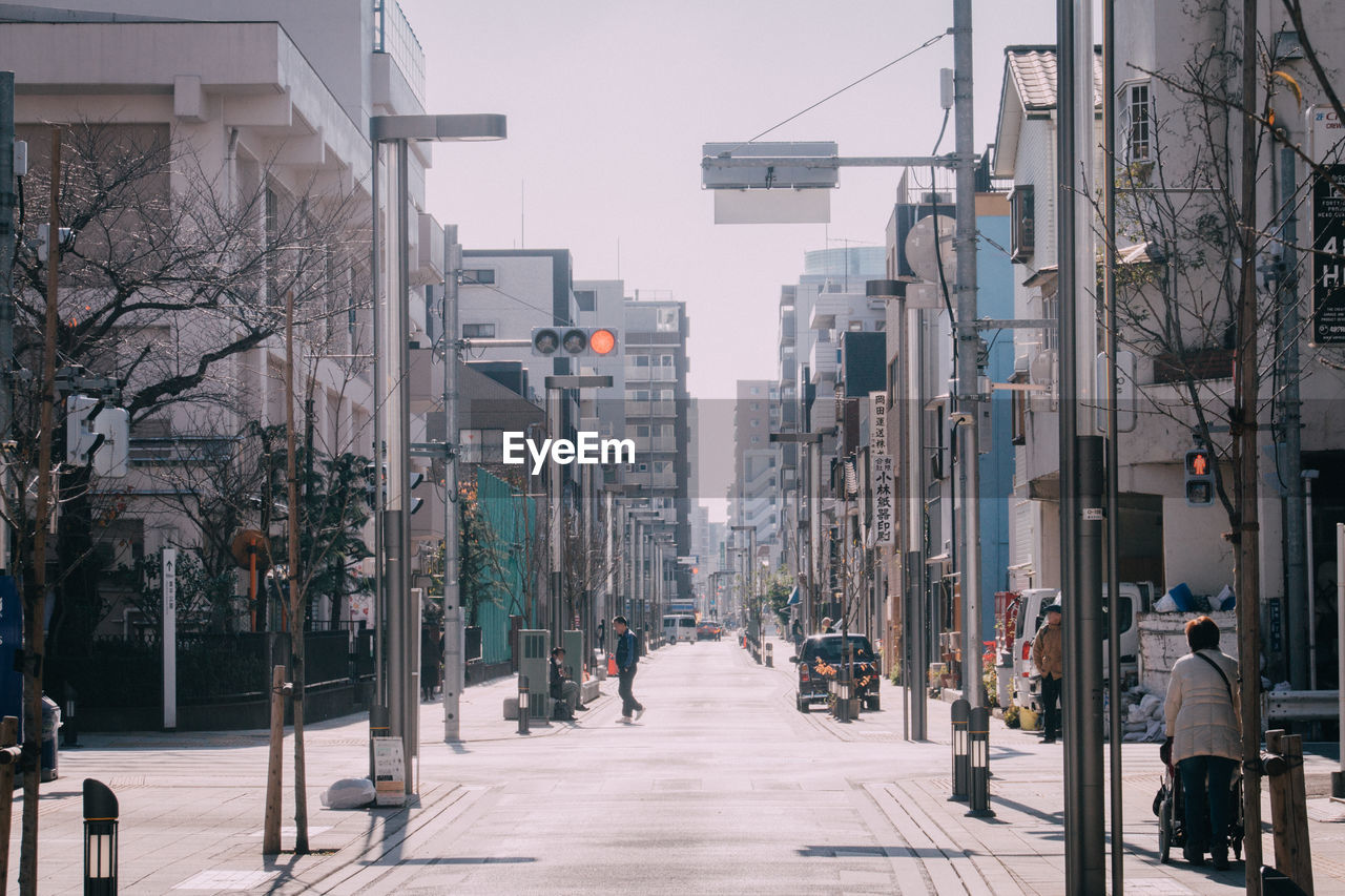 People on street amidst buildings in city