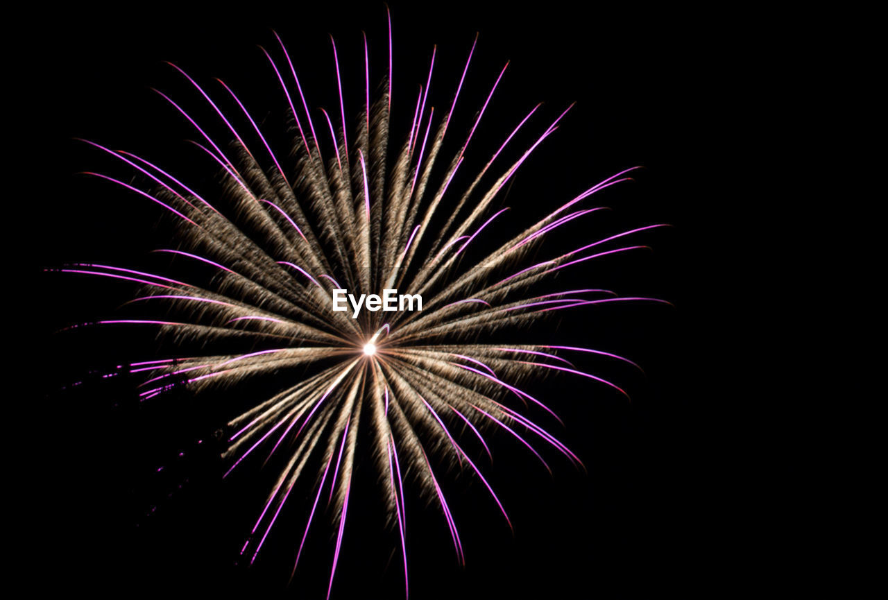 Low angle view of firework display at night