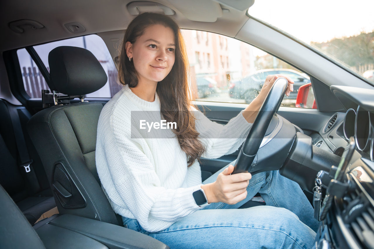 smiling woman sitting in car