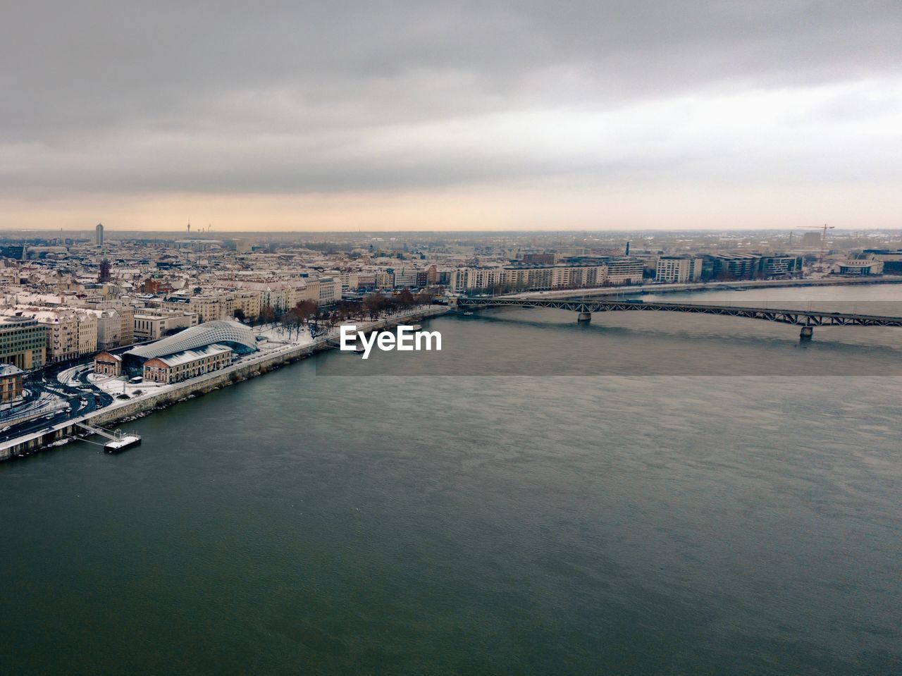 BRIDGE OVER RIVER BY CITY AGAINST SKY