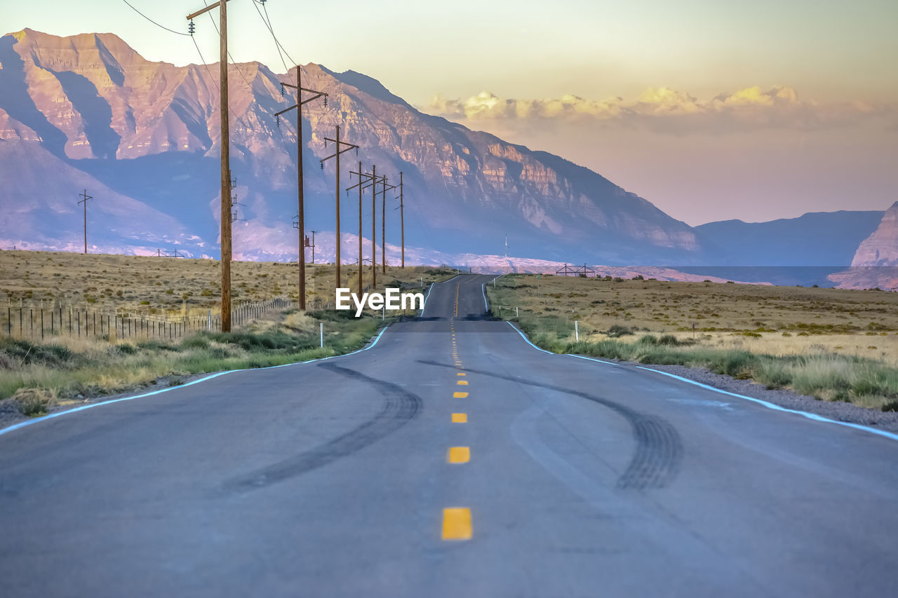 Road passing through landscape against sky