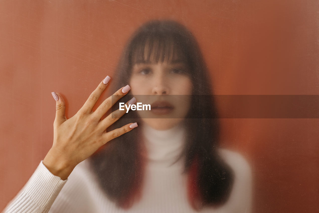 Hand touching plastic sheet with woman in background