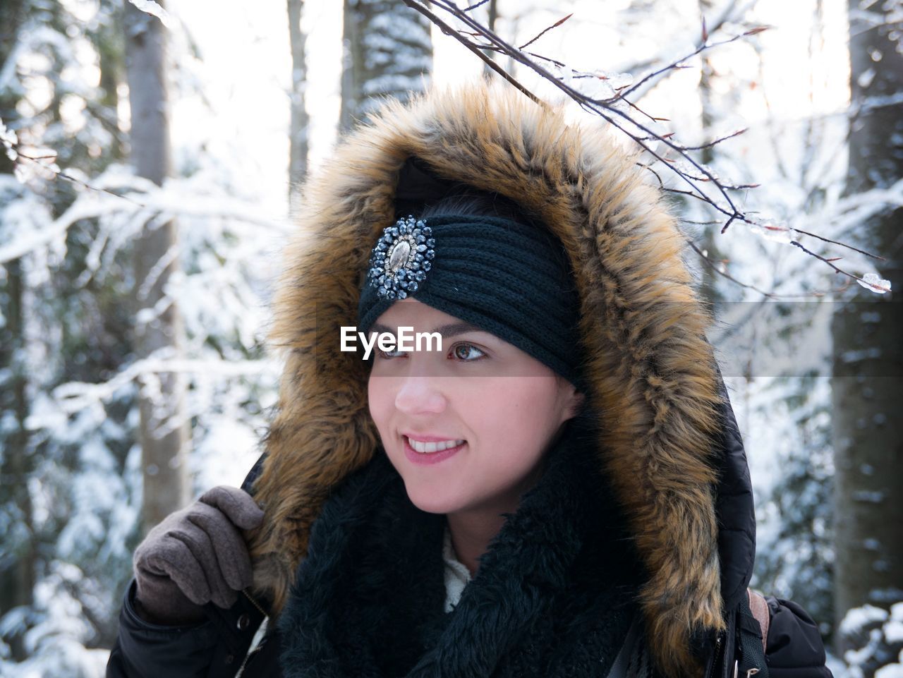 Close-up of smiling young woman wearing fur coat