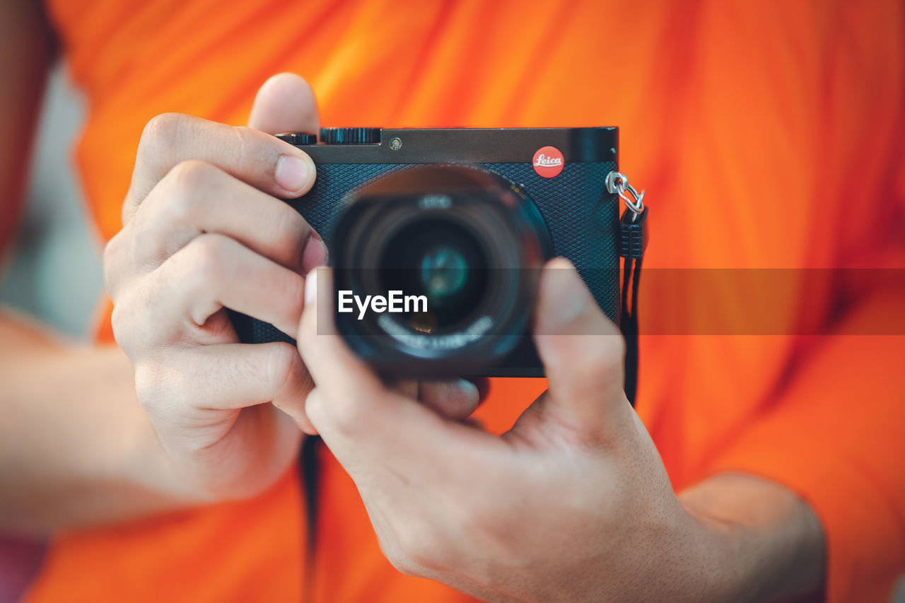 CLOSE-UP OF MAN HOLDING CAMERA