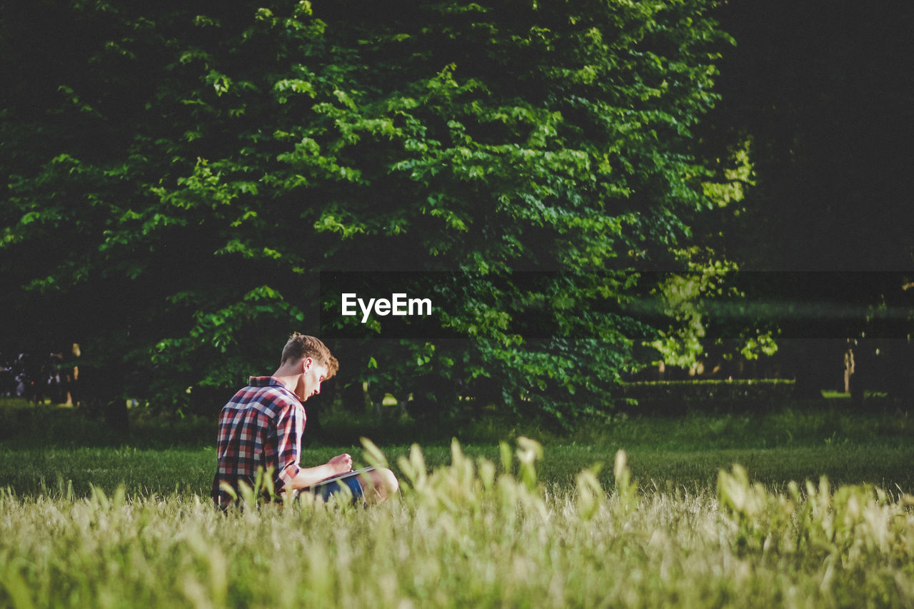 Man sitting on grassy land at park