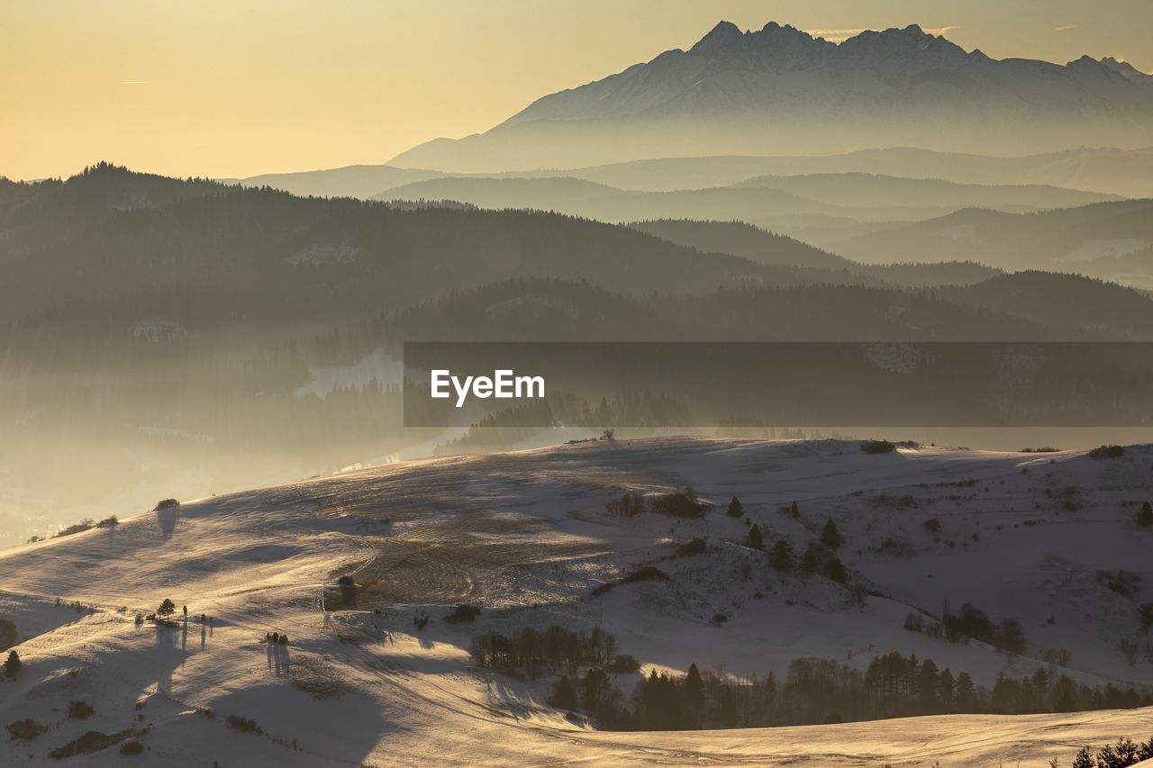 Scenic view of snow covered mountains against sky during sunset