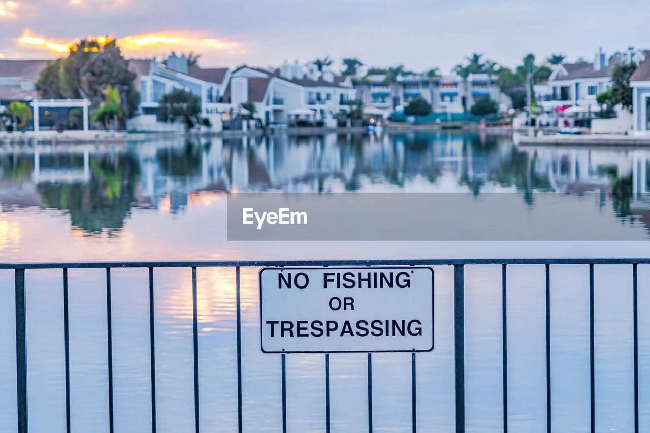 INFORMATION SIGN ON LAKE AGAINST SKY