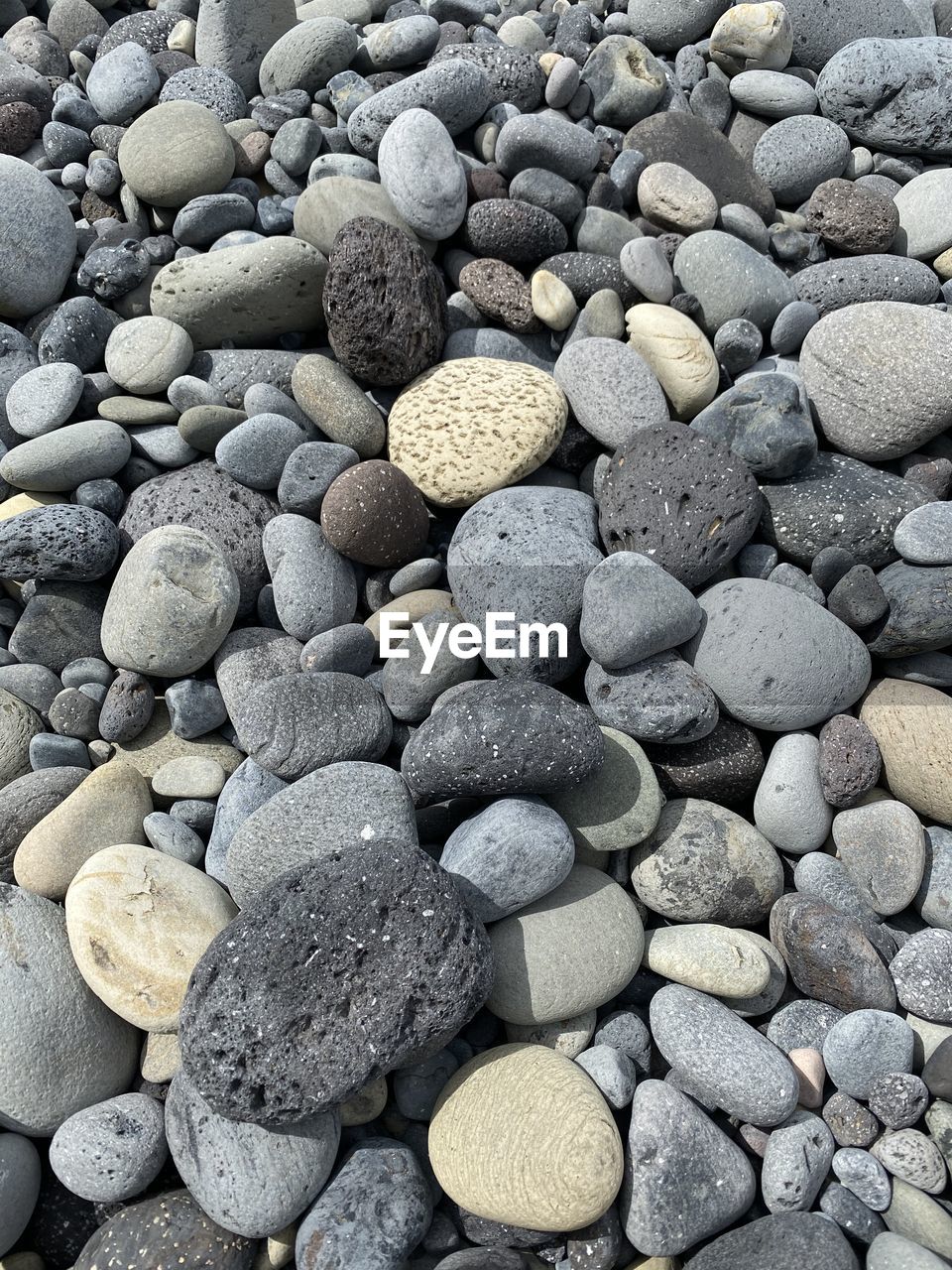 HIGH ANGLE VIEW OF STONES ON PEBBLES