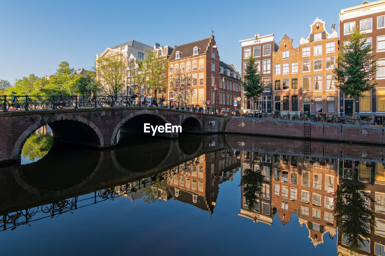 Reflections of buildings in the keizersgracht canal on a quiet summer morning in amsterdam