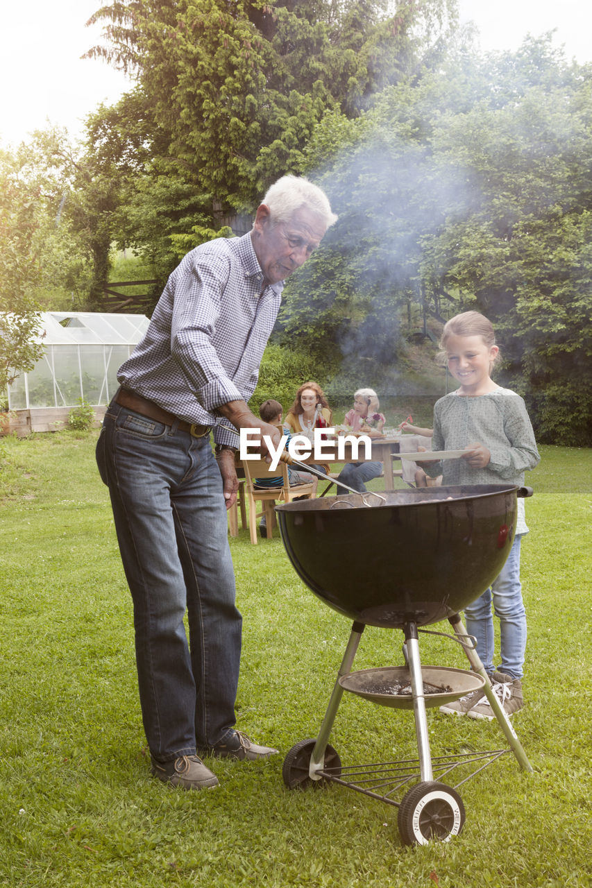 Grandfather and granddaughter on a family barbecue