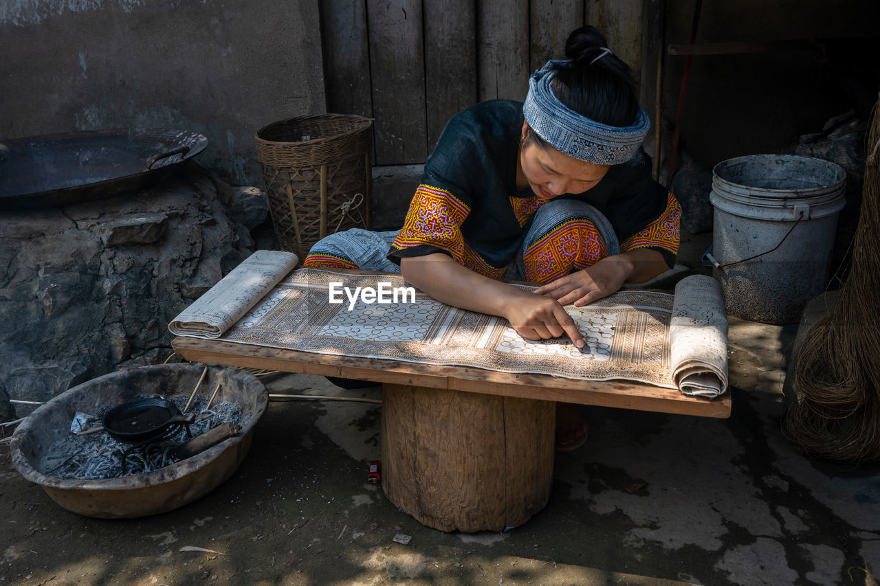 REAR VIEW OF WOMAN WORKING IN BASKET AT SHOP