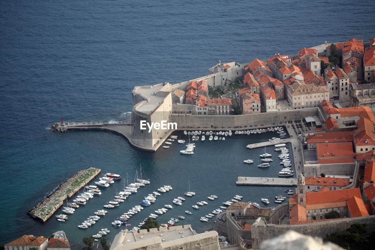 High angle view of townscape by harbor on sea